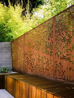 a wooden bench sitting in front of a wall with lots of holes on it's sides