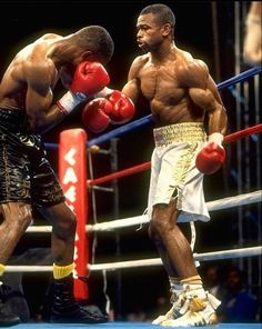 two men standing next to each other in a boxing ring