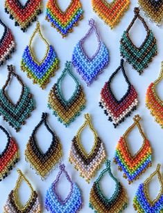 colorful beaded purses are arranged on a white surface with beads in the shape of bags