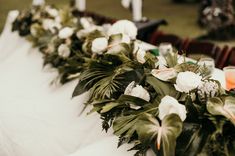 flowers and greenery are lined up on the table