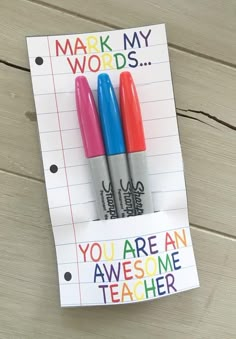 two pens sitting on top of a piece of paper that says, mark my words you are an awesome teacher