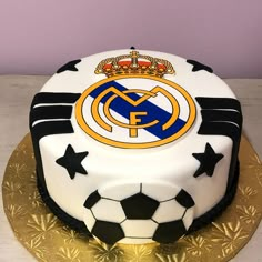 a cake decorated with a soccer ball and the logo of real madrid is on a table