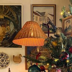 a decorated christmas tree in a living room with pictures on the wall and lights hanging above it