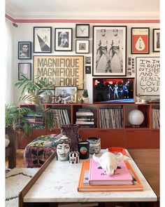 a living room filled with lots of furniture and pictures on the wall above it's coffee table