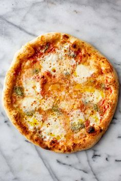 a pizza sitting on top of a white marble counter