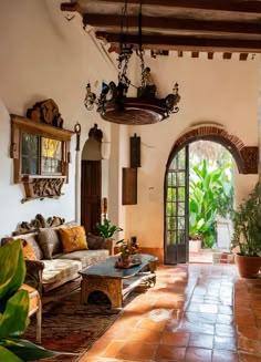 a living room filled with lots of furniture next to a doorway that leads into a courtyard