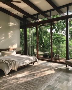 a large bed sitting in the middle of a bedroom next to a window filled with plants