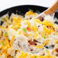 a skillet filled with potato salad and a wooden spoon