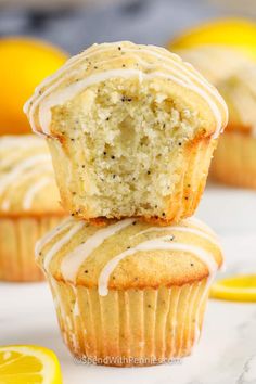 two lemon muffins stacked on top of each other with one bite taken out