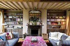 a living room with two couches and a coffee table in front of a fireplace