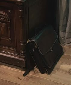 a black briefcase sitting on the floor next to a cabinet