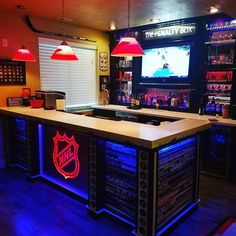 a bar with neon lights on it and a television in the back ground behind it