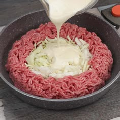 the ground beef is being poured with dressing