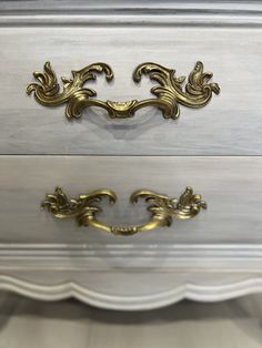 an ornate gold handle on a white dresser