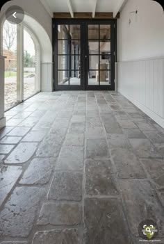 an empty room with stone floors and doors