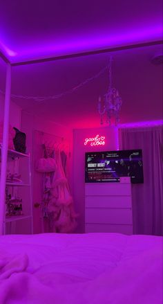 a bedroom with purple lighting and a pink light on the ceiling is lit by a chandelier