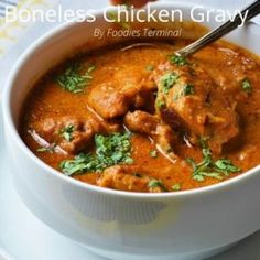 a white bowl filled with chicken gravy and garnished with parsley