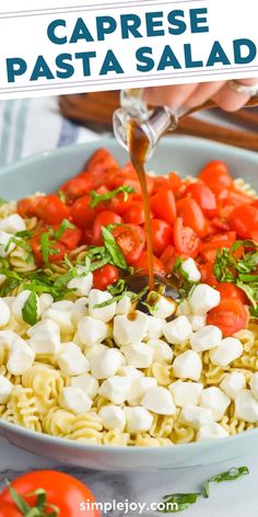 someone is pouring dressing over pasta with tomatoes and mozzarella