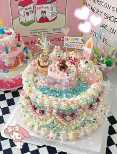 a birthday cake decorated with teddy bears and other decorations on a table next to a sign