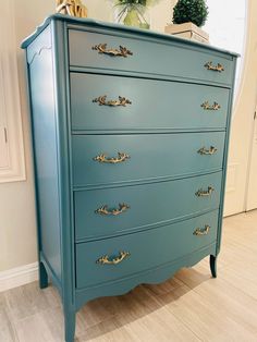 a blue dresser with gold handles in a room