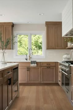 a kitchen filled with lots of wooden cabinets and counter top space next to a window