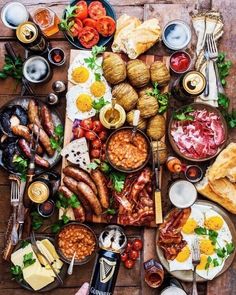 a wooden table topped with lots of different foods and meats on top of it