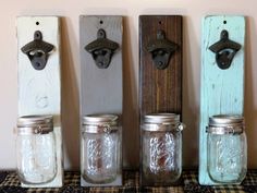 four mason jars are lined up in a row on a table with metal hooks and magnets