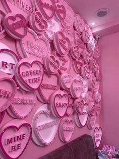 a pink room with lots of heart shaped signs on the wall