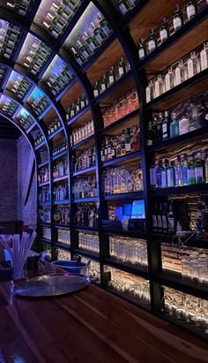 an image of a bar with many bottles on the shelves and lights in the ceiling