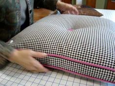 a person cutting fabric on top of a pillow