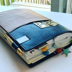 an open book sitting on top of a table next to a pen and pencil holder