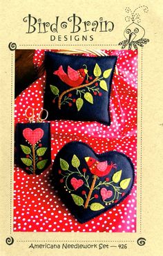 two black heart shaped bags with red flowers and leaves on them, sitting on a polka dot tablecloth