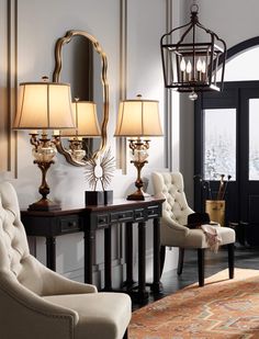 a living room filled with lots of furniture next to a mirror and chandelier