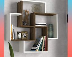 a shelf with several books on it and a plant in the corner next to it