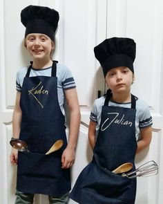 two young boys wearing aprons and hats with spoons in their hands, standing next to each other