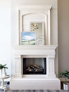 a white fireplace with a mirror above it