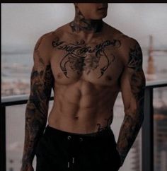 a man with tattoos on his chest standing in front of a cityscape and looking off into the distance