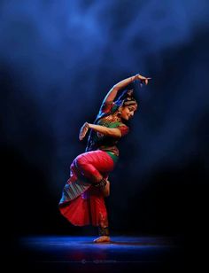 a woman is dancing on stage with her arms extended