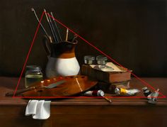 a still life with books, paintbrushes and other items in front of it