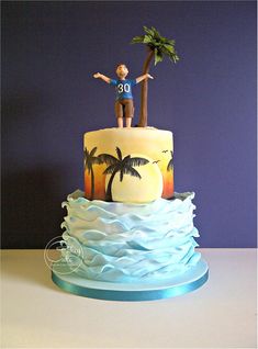 there is a cake that has a man on top and palm trees in the background