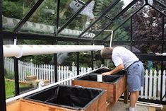 a man is working on some plants in a greenhouse