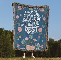 a woman standing in front of a blue blanket with flowers on it and the words jesus said come to me all that is very true and i will give you rest