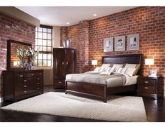 a bedroom with brick walls and furniture in the room, including a bed, dresser, mirror, and chest of drawers