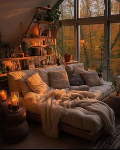 a living room filled with lots of furniture next to a large window covered in blankets