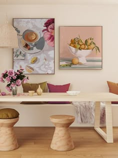 a dining room table with two vases filled with flowers and fruit on top of it