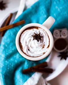 an overhead view of a cup of hot chocolate with whipped cream and cinnamon on top