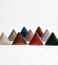 five different colors of velvet triangles on a white background