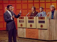 four men in suits and ties are on the set of an old tv show,