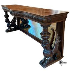 an ornately carved wooden table with glass on the top and bottom shelf is shown against a white background