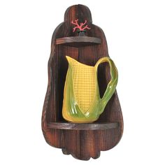 a wooden shelf with a yellow pitcher on it